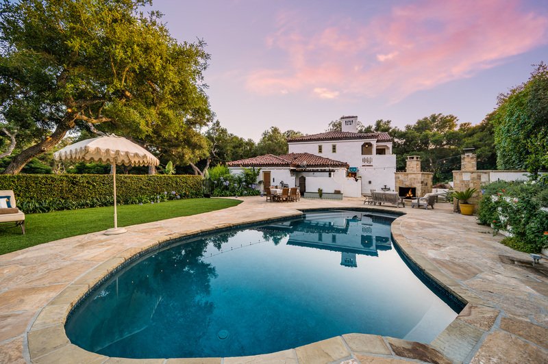 Alberca grande con palapa al lado y casa al fondo
